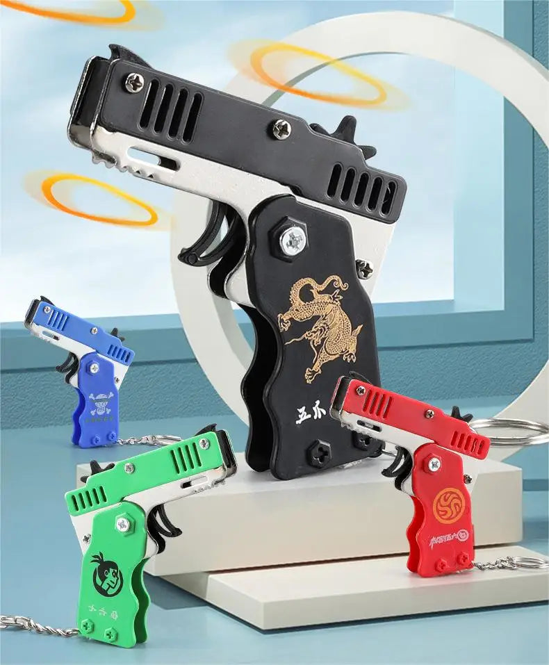 Wholesale Mini Rubber Bands Shoot Gun Alloy Metal Gun Pistol Plastic Key Chain Collapsible Funny Gun Toys For Kids